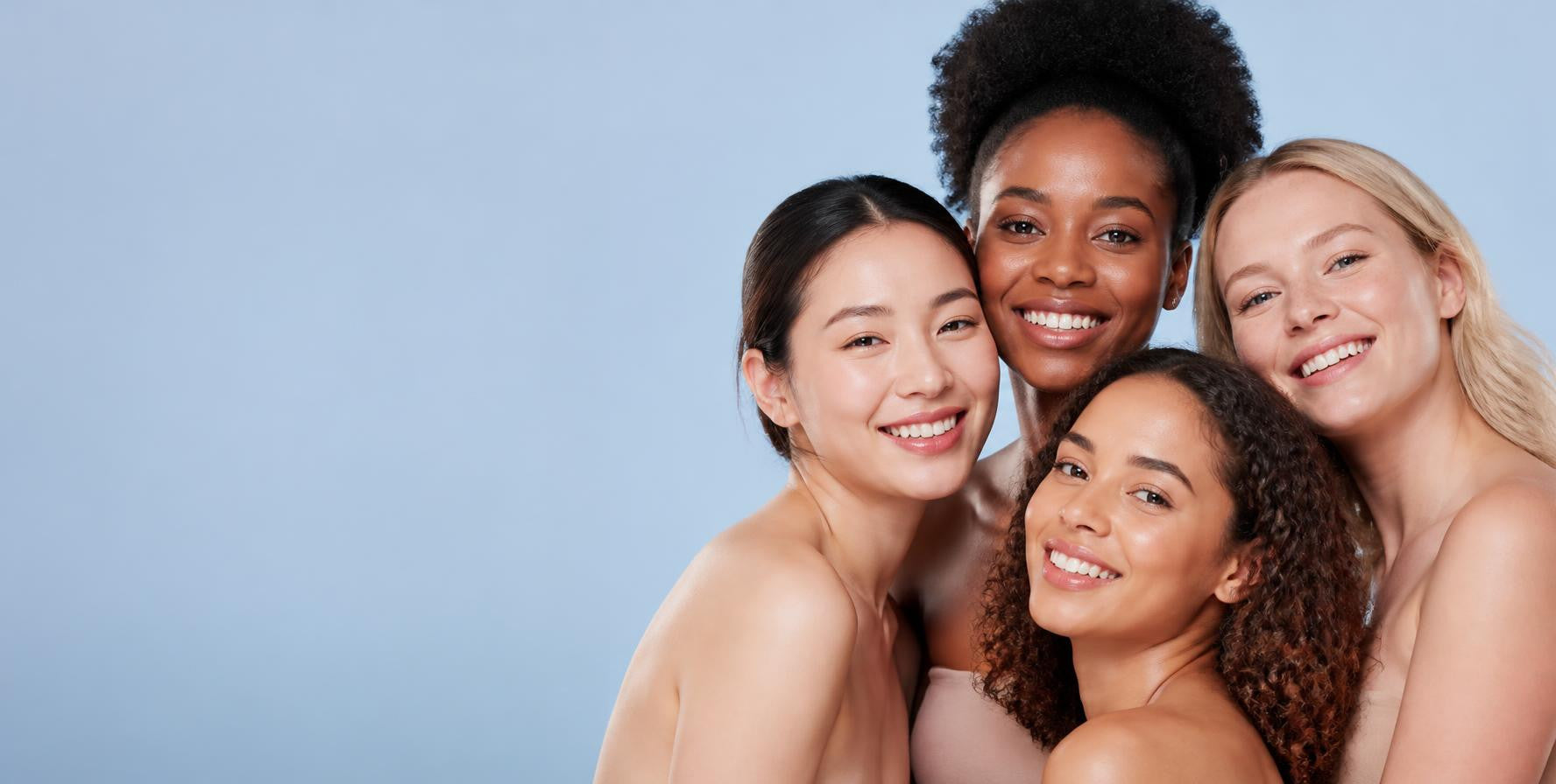 Four smiling women with glowing skin